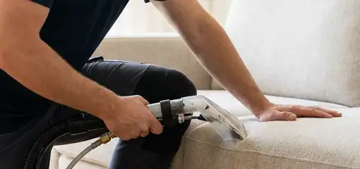 Professional upholstery cleaner deep-cleaning a fabric sofa with a handheld extraction tool, Chicago, IL.